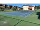 Community tennis court surrounded by lush landscaping and residential buildings, perfect for recreation and exercise at 3077 Casa Del Sol Cir # 207, Clearwater, FL 33761