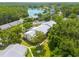 Aerial view of condos with lake, pool, green space, and lush tree coverage at 3114 Lake Pine Way # G1, Tarpon Springs, FL 34688