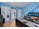 Blue bedroom featuring wood floors, closet, and doorway into an adjoining room at 3114 Lake Pine Way # G1, Tarpon Springs, FL 34688