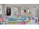 Bright bedroom features a large closet, ensuite bathroom, and colorful tropical-themed bedding and décor at 3114 Lake Pine Way # G1, Tarpon Springs, FL 34688