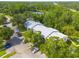 Aerial view of condo buildings, parking, and green space near the highway at 3114 Lake Pine Way # G1, Tarpon Springs, FL 34688