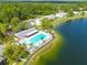 Aerial view of a community pool, jacuzzi, and lush landscaping on a sunny day at 3114 Lake Pine Way # G1, Tarpon Springs, FL 34688
