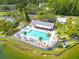 Aerial view of community pool with lounge chairs, umbrellas, and lush landscaping at 3114 Lake Pine Way # G1, Tarpon Springs, FL 34688