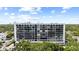 Exterior of a multi-story condominium building with large windows, surrounded by lush green trees at 3211 W Swann Avenue # 707, Tampa, FL 33609