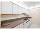 A functional kitchen is shown with a double sink, ample white cabinets, neutral countertops, and modern appliances at 3211 W Swann Avenue # 707, Tampa, FL 33609