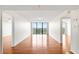 A light-filled living room boasts beautiful hardwood floors and balcony access, with a view of lush greenery at 3211 W Swann Avenue # 707, Tampa, FL 33609