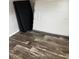 Bedroom with dark wood-look flooring and new mattresses wrapped in plastic at 3221 Roxborough Ave, Clearwater, FL 33762