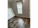 Bedroom featuring wood-look floors, natural light, and a modern window shade at 3221 Roxborough Ave, Clearwater, FL 33762