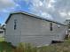 The side of the house is clad in gray siding, showing multiple windows, and a small set of stairs at 3221 Roxborough Ave, Clearwater, FL 33762