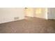 Living room showcasing neutral carpet and paint; doorway to the kitchen and front entrance at 37045 North Ave, Dade City, FL 33523
