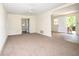 Spacious living room features neutral carpet, a ceiling fan, and adjacent access to kitchen area at 37045 North Ave, Dade City, FL 33523