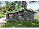 Side view showing the home's siding, new roof, neat landscaping, and outdoor utility connections at 37045 North Ave, Dade City, FL 33523