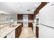 Bright kitchen featuring granite countertops, stainless steel appliances, wood-look flooring, and ample cabinet space at 3917 Casaba Loop, Valrico, FL 33596