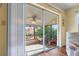 Enclosed lanai featuring tile floor, ceiling fan, and comfortable seating overlooking a lush backyard at 4036 Davit Dr, New Port Richey, FL 34652