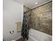 Bathroom featuring a bathtub with tiled walls and wood-look floors at 4221 W Spruce St # 2302, Tampa, FL 33607