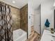 Bathroom showcasing a bathtub with tiled walls and wood-look floors at 4221 W Spruce St # 2302, Tampa, FL 33607