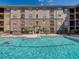 View of a crystal blue swimming pool and lounge chairs at 4221 W Spruce St # 2302, Tampa, FL 33607