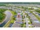 An aerial view showcases a two-story home with a screened-in pool and lush backyard backing onto a serene lake at 4633 Ballantrae Blvd, Land O Lakes, FL 34638