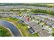 An aerial view of a two-story home with a private screened pool, lush lawn, and access to a community lake at 4633 Ballantrae Blvd, Land O Lakes, FL 34638