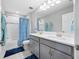 Bright bathroom with double vanity, large mirror, tub/shower combo, and gray cabinetry at 4633 Ballantrae Blvd, Land O Lakes, FL 34638