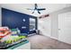 Bright bedroom with a blue accent wall, carpet, ceiling fan, window and closet at 4633 Ballantrae Blvd, Land O Lakes, FL 34638