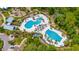 Aerial view of a resort-style community pool area with multiple pools, lounge chairs, and lush landscaping at 4633 Ballantrae Blvd, Land O Lakes, FL 34638