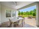 View of the covered patio area with a ceiling fan and outdoor table with seating at 4633 Ballantrae Blvd, Land O Lakes, FL 34638