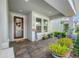 Inviting front porch with brick flooring, decorative plants, and a welcoming front door at 4633 Ballantrae Blvd, Land O Lakes, FL 34638