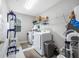A utilitarian laundry room with front loading washer and dryer and storage at 4633 Ballantrae Blvd, Land O Lakes, FL 34638
