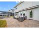 View of the patio area with an outdoor firepit, gray wicker furniture, and door leading inside at 4633 Ballantrae Blvd, Land O Lakes, FL 34638