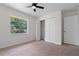 Bedroom featuring neutral carpet, a window view, and closet storage at 4706 Fox Hunt Dr, Tampa, FL 33624