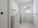 Bright laundry room with appliances, storage cabinets, and a window at 4706 Fox Hunt Dr, Tampa, FL 33624