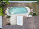 Aerial view of a backyard pool featuring a rock waterfall feature and a spacious patio at 4706 Fox Hunt Dr, Tampa, FL 33624
