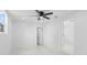 Bright bedroom featuring white walls, ceiling fan, and doorway to bathroom at 4803 Sierra Madre Dr, Tampa, FL 33634