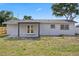 A single-story home featuring a neutral paint color, a covered patio, and double doors at 4803 Sierra Madre Dr, Tampa, FL 33634
