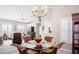 Bright dining area with a chandelier, glass table, and wicker chairs at 5117 Fairway One Dr, Valrico, FL 33596