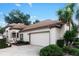 A well-kept home featuring an attached two-car garage and well-manicured landscaping at 5117 Fairway One Dr, Valrico, FL 33596