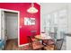 Eat-in kitchen with a mosaic table, red accent wall, and shuttered window at 5117 Fairway One Dr, Valrico, FL 33596