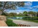 Scenic view of a pond with mature trees and landscaping, perfect for enjoying the outdoors at 5117 Fairway One Dr, Valrico, FL 33596