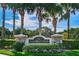 Community entrance sign surrounded by beautiful landscaping and tall palm trees at 5117 Fairway One Dr, Valrico, FL 33596