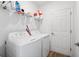 Functional laundry room with shelving, a full-size washer and dryer, and convenient access door at 5511 Badini Way, Palmetto, FL 34221