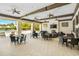 An open-air patio features comfortable seating, ceiling fans, and a fireplace, perfect for relaxing by the pool at 5511 Badini Way, Palmetto, FL 34221