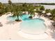 An aerial view of a luxurious pool area with palm trees and white canopies, overlooking a serene lake at 5511 Badini Way, Palmetto, FL 34221