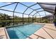 This screened-in pool area features a picturesque lake view, inviting relaxation and outdoor enjoyment at 5511 Badini Way, Palmetto, FL 34221