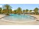A beautiful community pool surrounded by lush palm trees and comfortable lounge chairs for relaxation at 5511 Badini Way, Palmetto, FL 34221