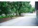 A spacious backyard with a concrete area, greenery, mature trees, and a fence at 5625 Gateway Dr, Tampa, FL 33615