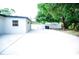 Spacious backyard with a concrete slab, lush trees, and a white fence at 5625 Gateway Dr, Tampa, FL 33615