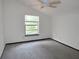 Bedroom with white walls, a window looking out at trees, and a ceiling fan at 5736 116Th N Ave, Pinellas Park, FL 33782