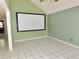 Empty room with vaulted ceilings and tile flooring with a screen and green walls at 5736 116Th N Ave, Pinellas Park, FL 33782