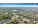 Expansive aerial view featuring a lake, homes, and lush greenery under a blue sky at 5808 Silver Moon Ave, Tampa, FL 33625